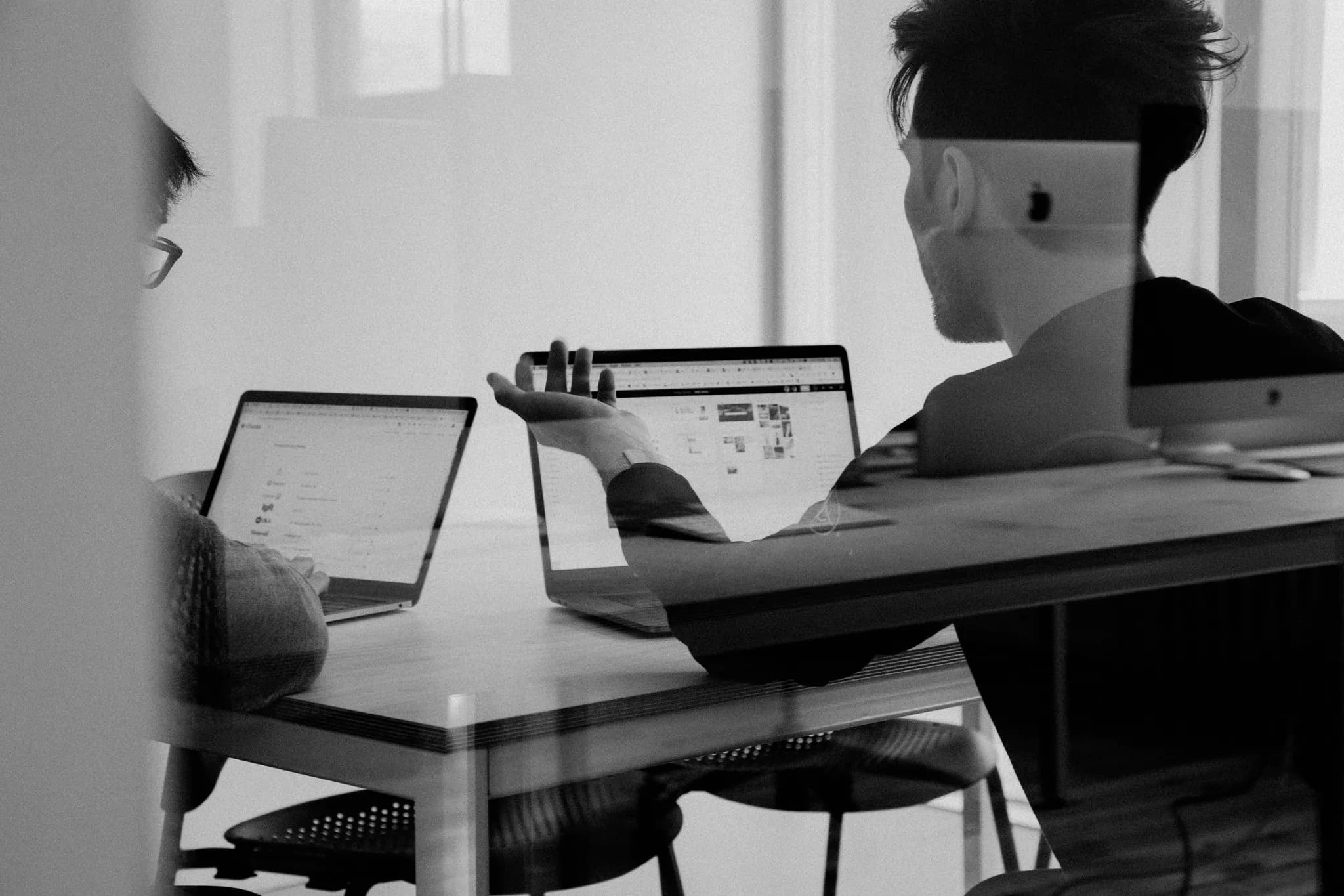 Two OT Markets specialists reviewing markets on laptops.
